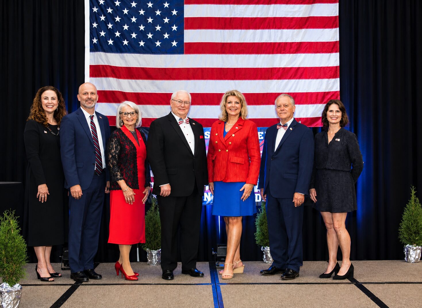 Group of leaders in front of an American flag.